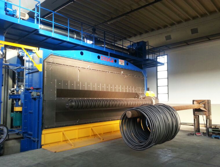 Grenailleuse industrielle TOSCA bleue et grise traitant une grande bobine de fil d'acier