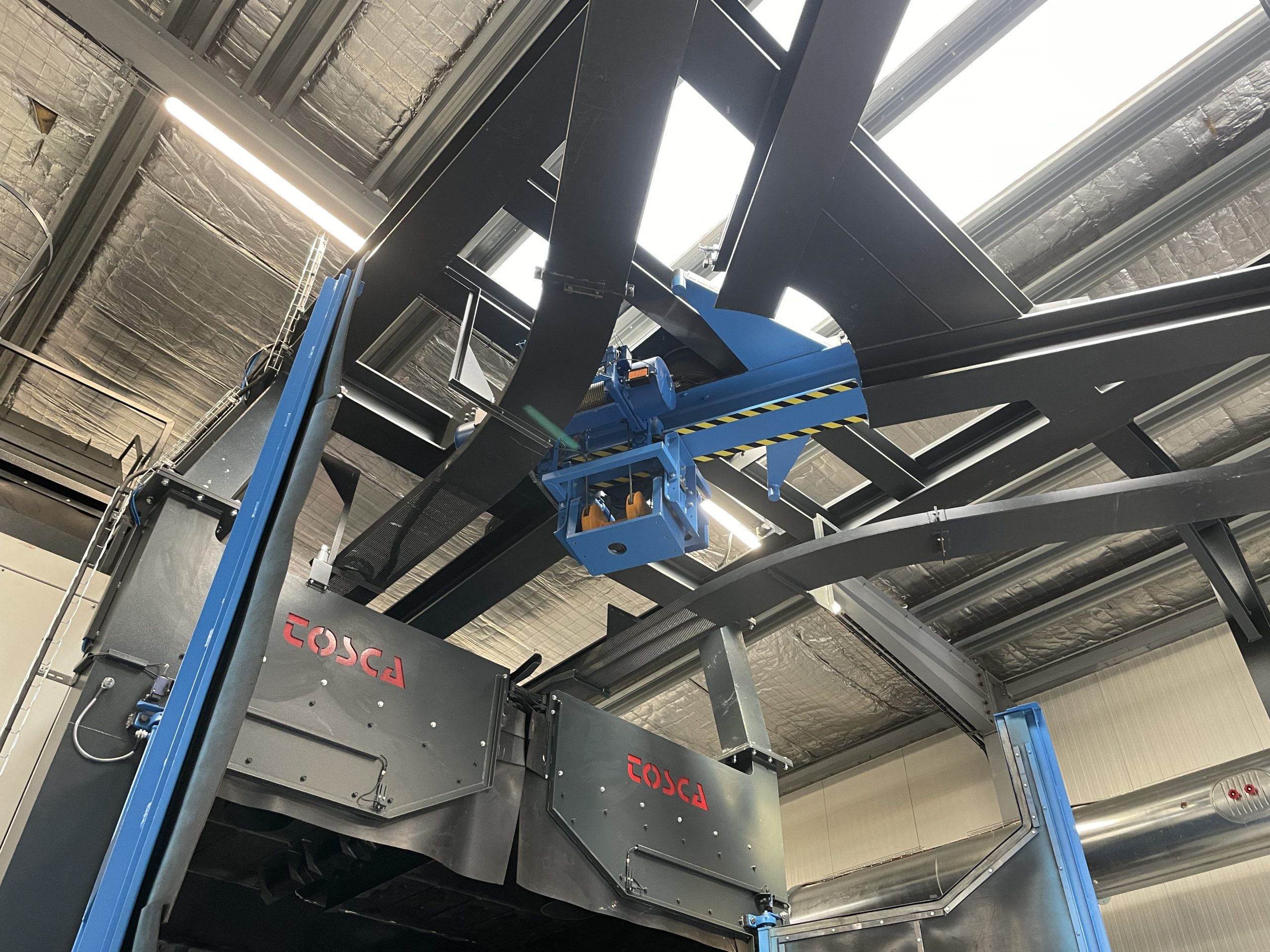 Grenailleuse à palan TOSCA avec système de manutention automatisé dans atelier industriel